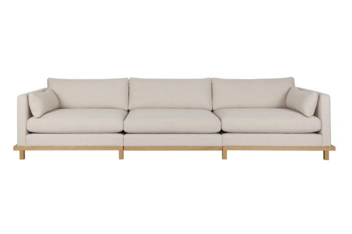Sofá largo nórdico moderno con base de madera de roble arena tapizado en tela color crema.