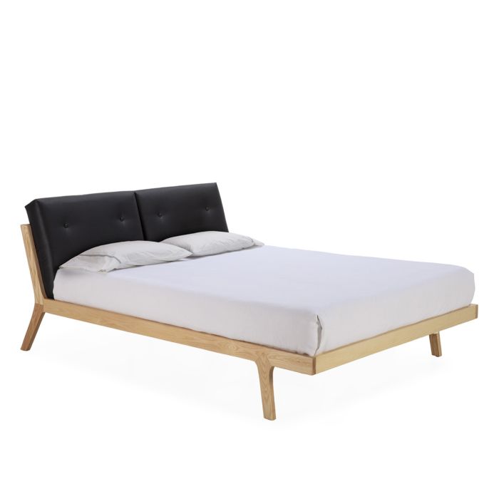 Cama nórdica moderna en madera natural con cojines de p.piel negra.