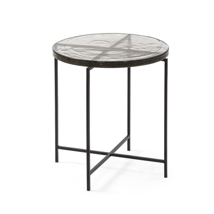 Mesa auxiliar industrial sobre de vidrio y estructura de metal negro.