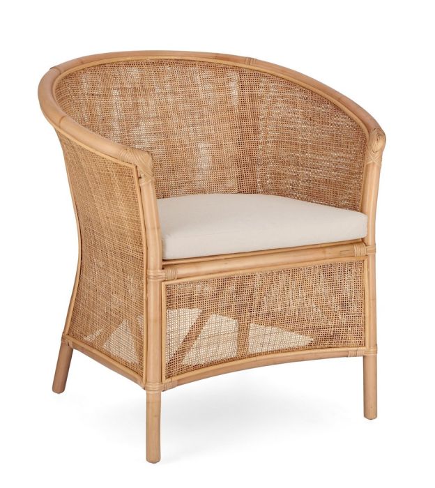 Sillón tropical con estructura de ratán natural y cojín tono beige.