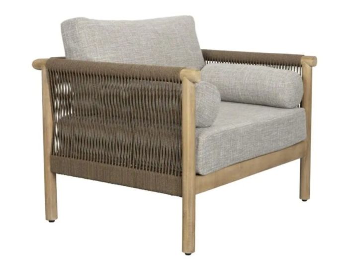 Sillón de exterior nórdico en madera de acacia grisácea con cojines beige.