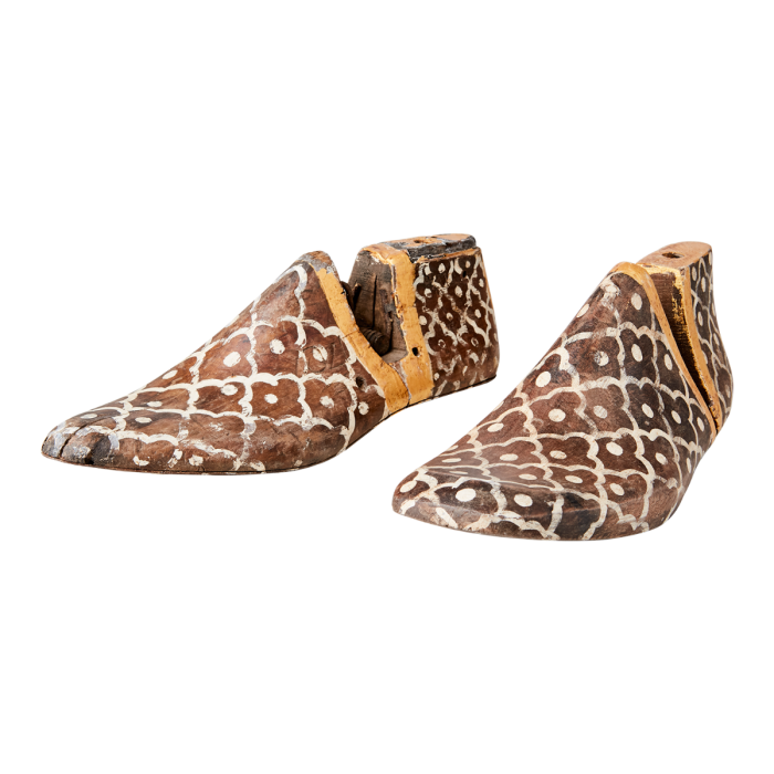 Molde de zapatos étnico en madera y hierro en tonos tierra con motivos geométricos florales.