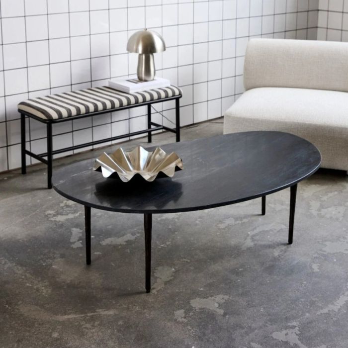 Mesa de centro con sobre de mármol negro y patas de hierro.
