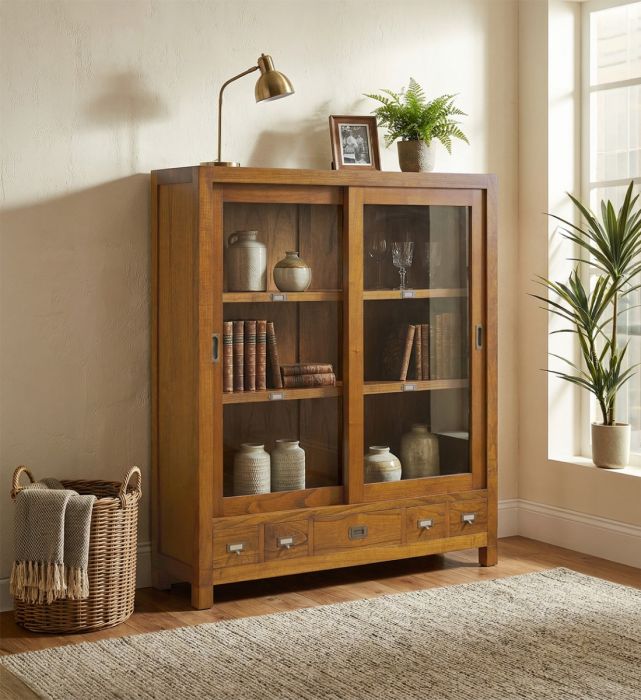 Vitrina en madera de mindi natural con puertas de cristal y detalles en bronce.
