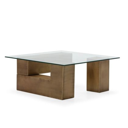 Mesa de centro art decó con sobre de cristal transparente y base geométrica de metal en latón envejecido.