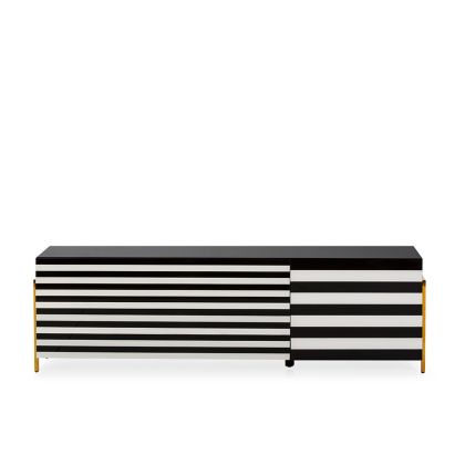 Mueble de TV en cristal con rayas blanca y negro y patas de acero dorado.