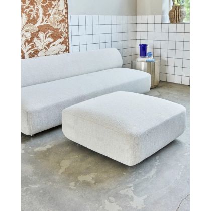 Puf en madera contrachapada tapizada en tejido blanco roto con patas de aluminio plateado.