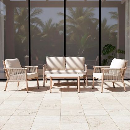Conjunto de sofá jardín en ratán, acero color natural, cojines blancos y piedra blanca.