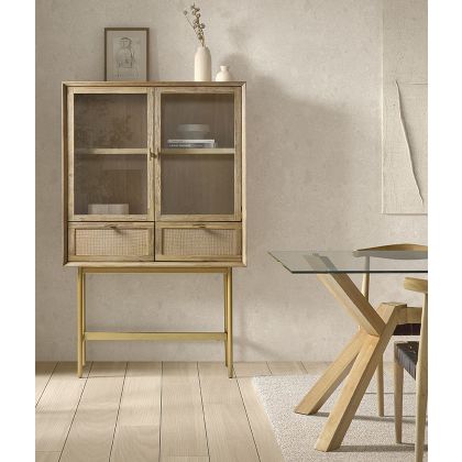 Vitrina en madera natural y puertas de vidrio con base dorada.