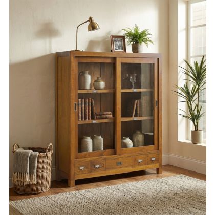 Vitrina en madera de mindi natural con puertas de cristal y detalles en bronce.